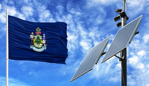 Maine flag waving next to solar panel