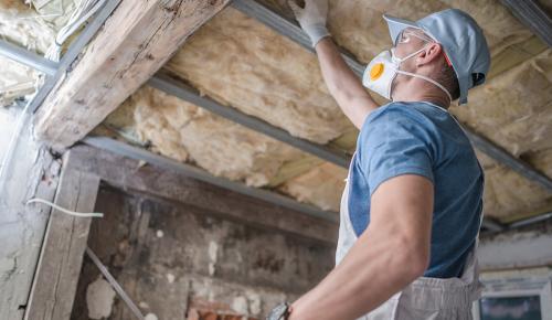 Worker upgrading home insulation for energy efficiency